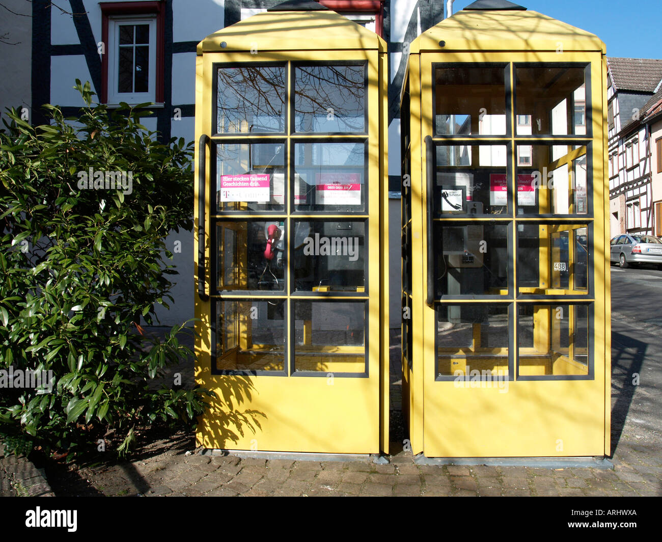 Due vecchie gialle le cabine telefoniche in un angolo di un tipico tedesco città vecchia con metà case con travi di legno Gelnhausen Hesse in Germania Foto Stock