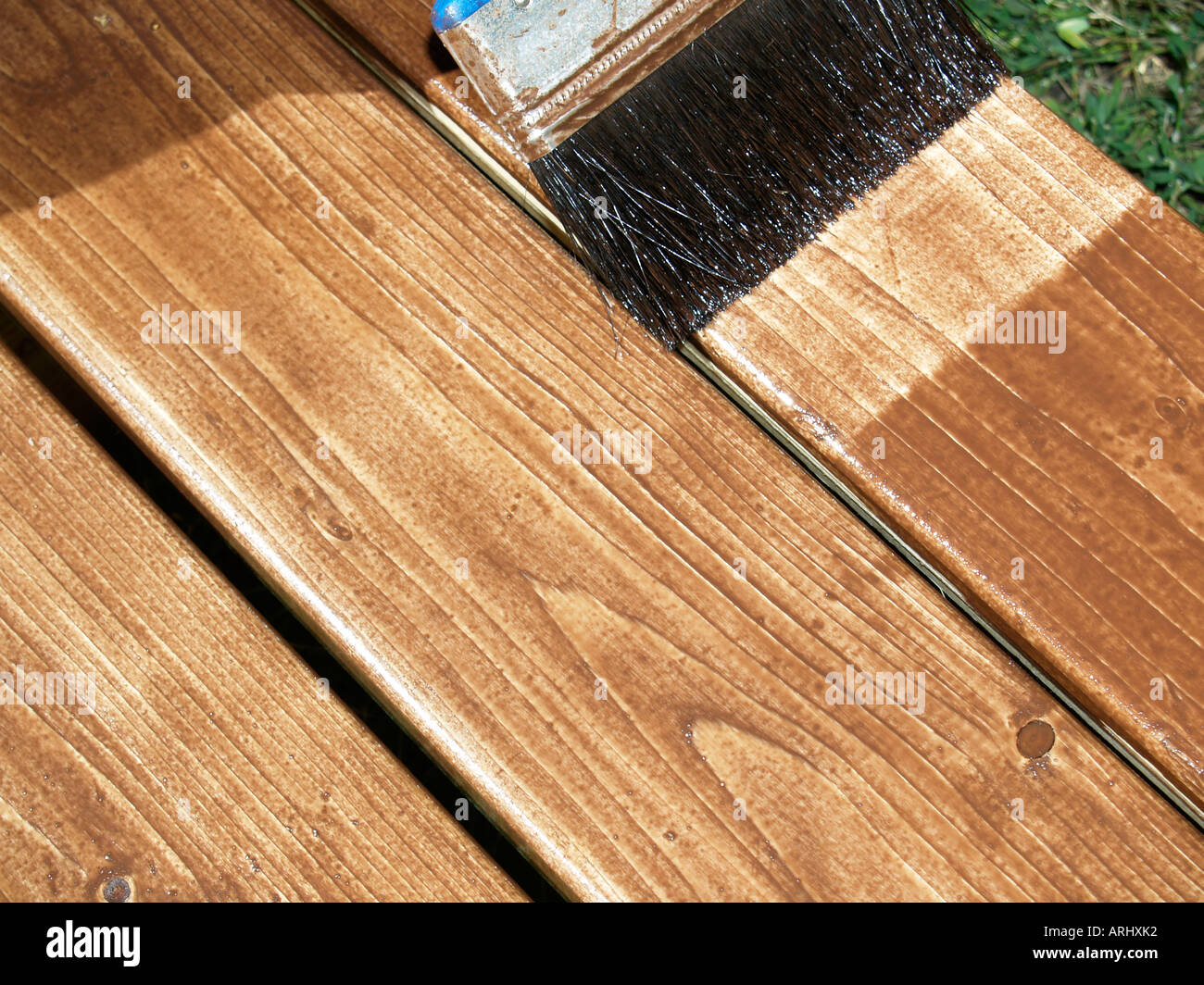 Il trattamento del legno con rivestimento protettivo di una spazzola di vernice della pittura con doghe in legno Foto Stock