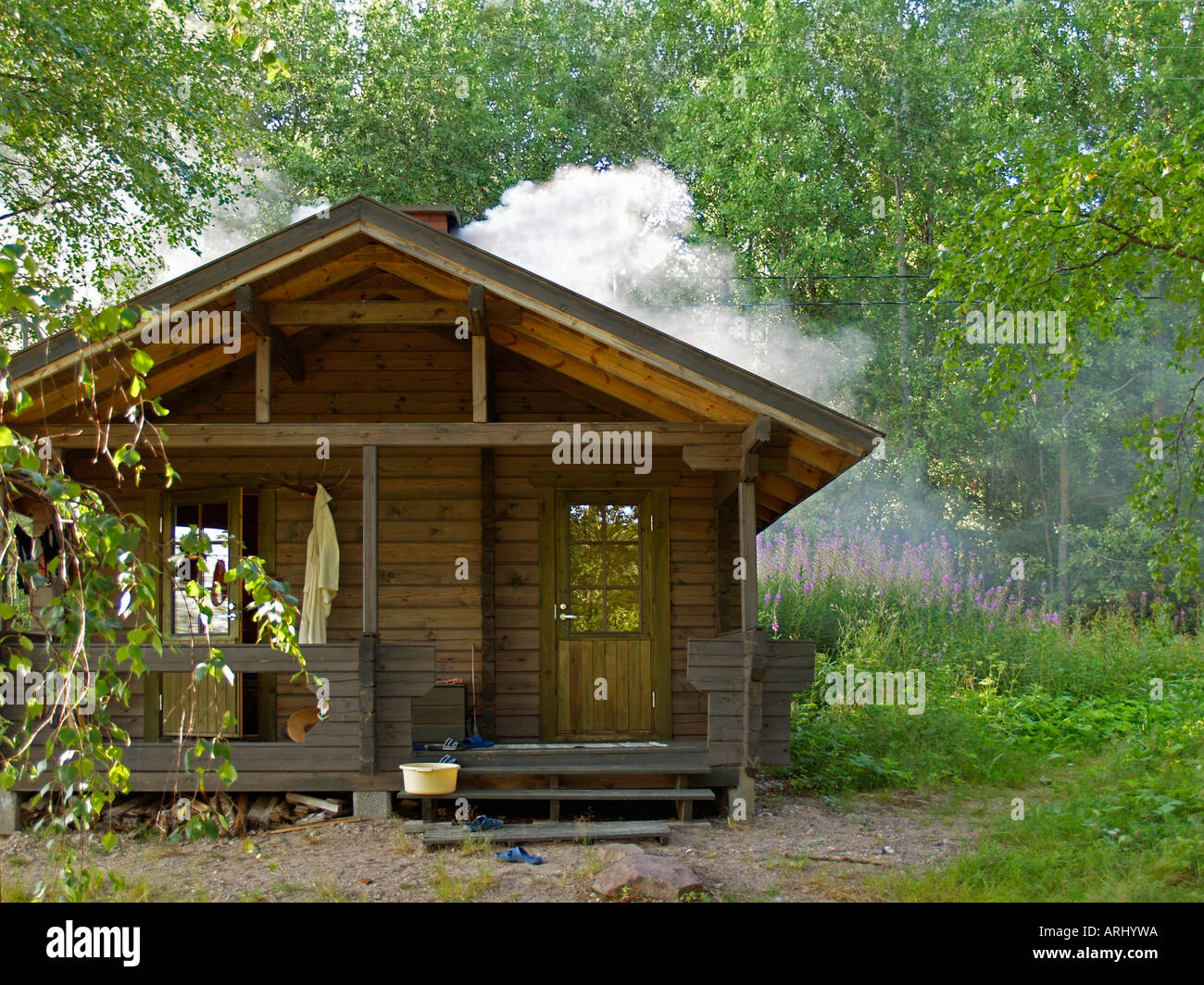 Sauna reeking mediante riscaldamento di una sauna in legno nella natura in Finlandia Foto Stock