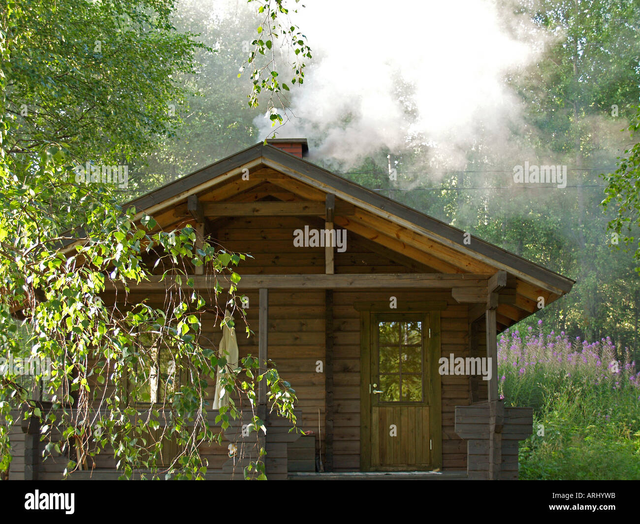 Sauna reeking mediante riscaldamento di una sauna in legno nella natura in Finlandia Foto Stock
