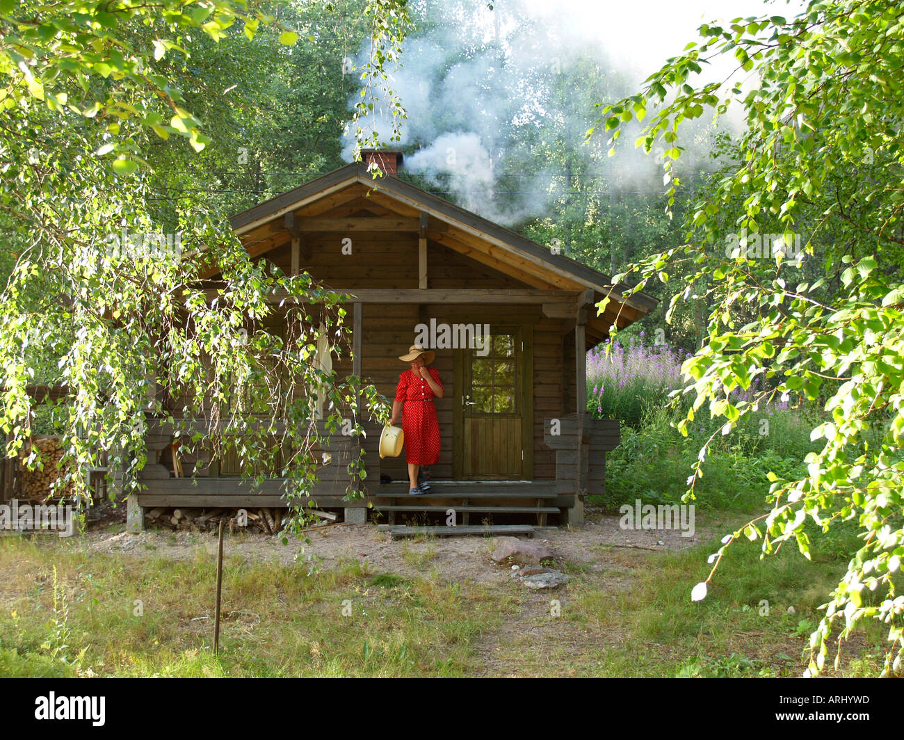 Sauna reeking mediante riscaldamento di una sauna in legno nella natura in Finlandia Foto Stock