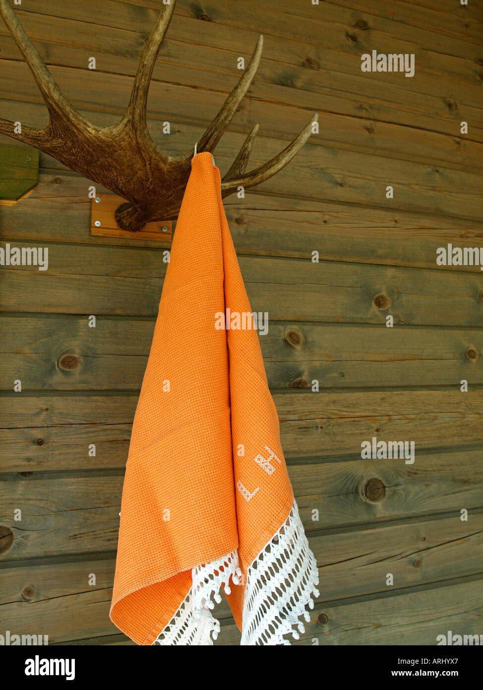 Orange asciugamani per sauna appesa al gancio costituito da corna di alce Foto Stock