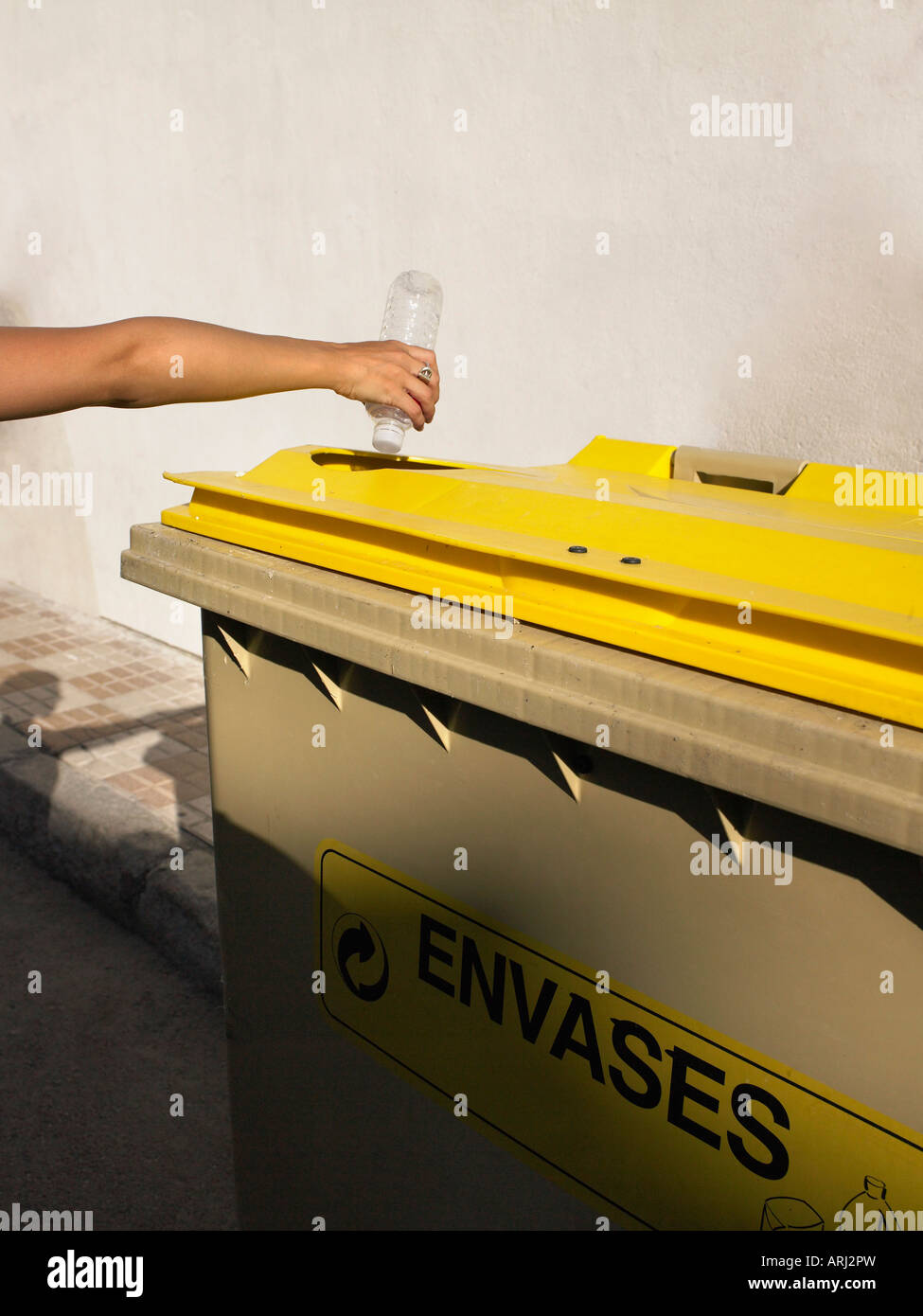 Donna mettendo una bottiglia in un cestino Foto Stock