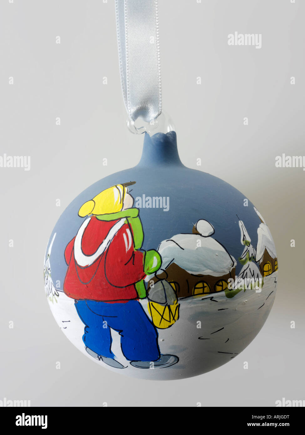 Tradizionale festa di Natale pallina di vetro decorazione a sfera con un bambino nella neve e coperta di neve case in blu e Foto Stock