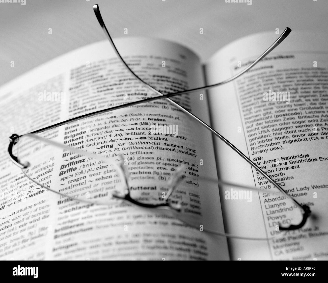 Paio di Occhiali giacente su un libro aperto evidenziando la parola Brille, occhiali attraverso uno della lente Foto Stock