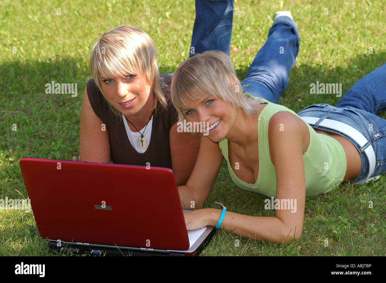 Junge Mädchen mit laptop auf wiese - giovani ragazze giacente in erba lavora con i notebook Foto Stock