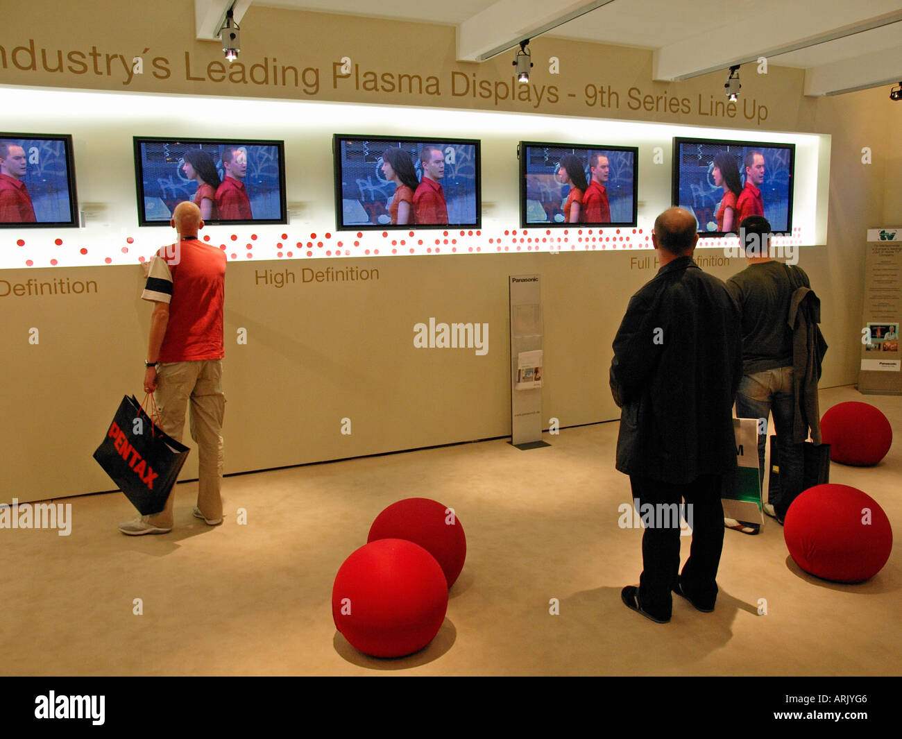 Tre uomini cittadini consumatori guardando dei televisori a schermo piatto al plasma HDTV LCD TV ad alta definizione Colonia Germania Foto Stock