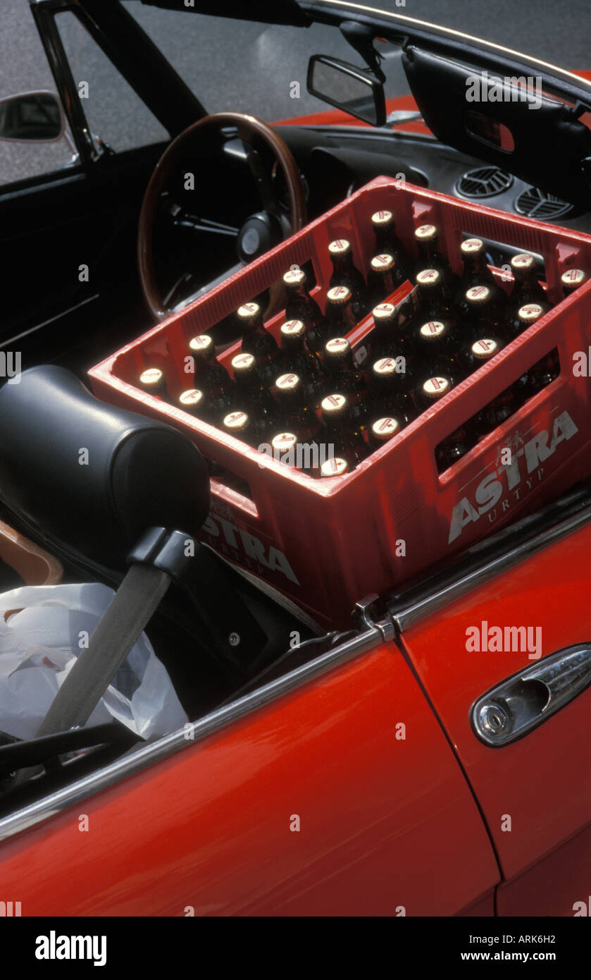 Bottiglie di birra tradizionale "Astra", sapientemente stivato in un caso accanto al sedile del conducente in un rosso convertibili, Amburgo, Germania Foto Stock