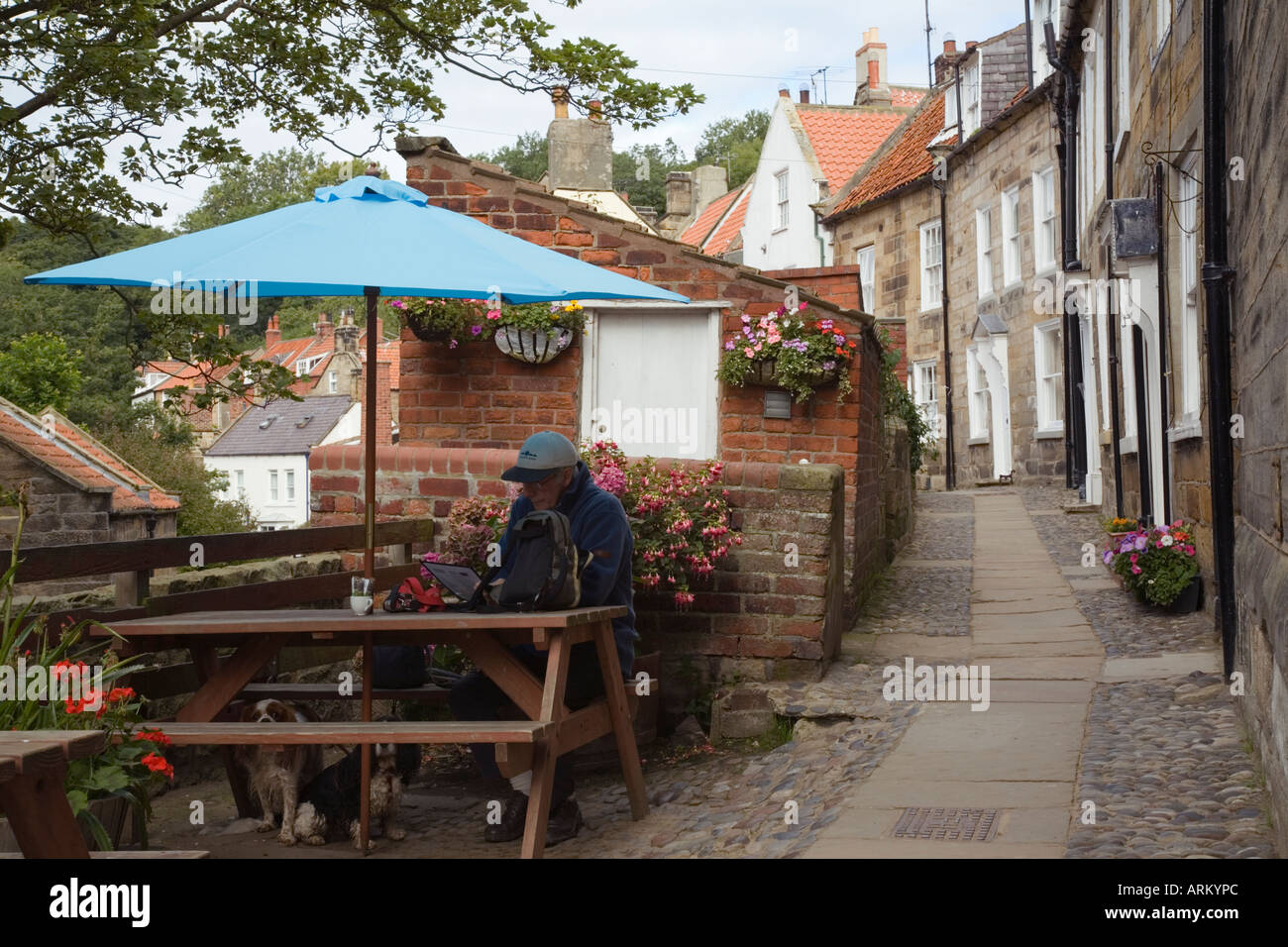 Case a schiera in "Chapel Street' con blue ombrellone da cafe nella vecchia parte della baia di "Robin Hood's Bay' Yorkshire Inghilterra Foto Stock