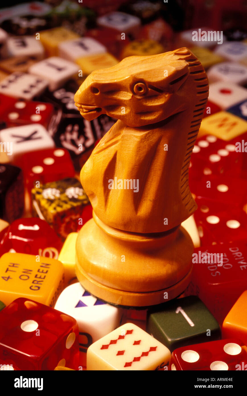 Pezzo degli scacchi knight seduto sulla parte superiore dei vari tipi di dadi di gioco Foto Stock