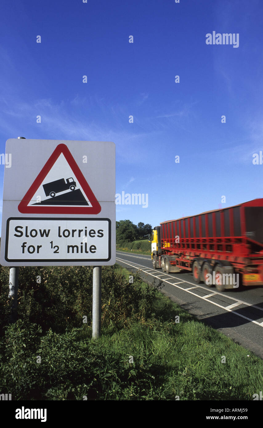 Autocarro passando un cartello di segnalazione di slow automezzi pesanti in strada davanti a64 Yorkshire Regno Unito Foto Stock