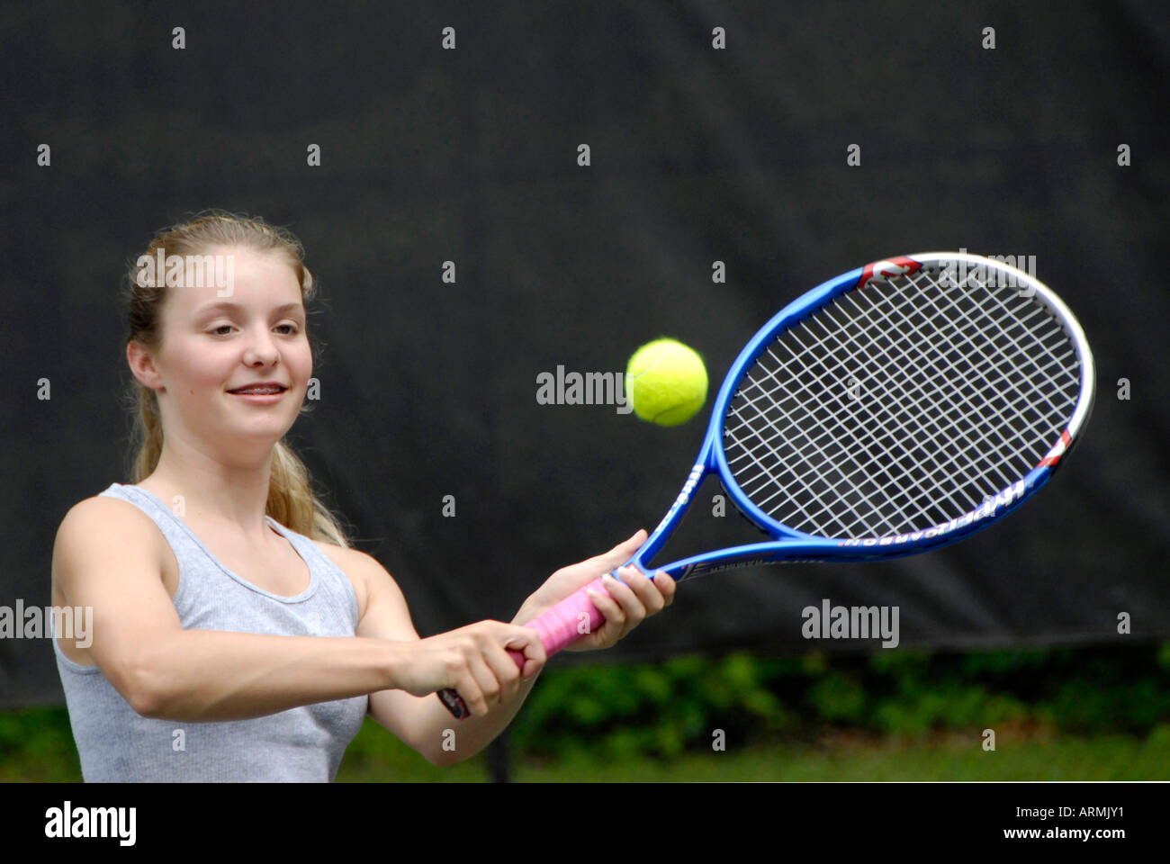 Nella scuola media e alta scuola di adolescenti di età prendere lezioni di tennis in estate un arricchimento e allo sviluppo pubblico programma della città Foto Stock