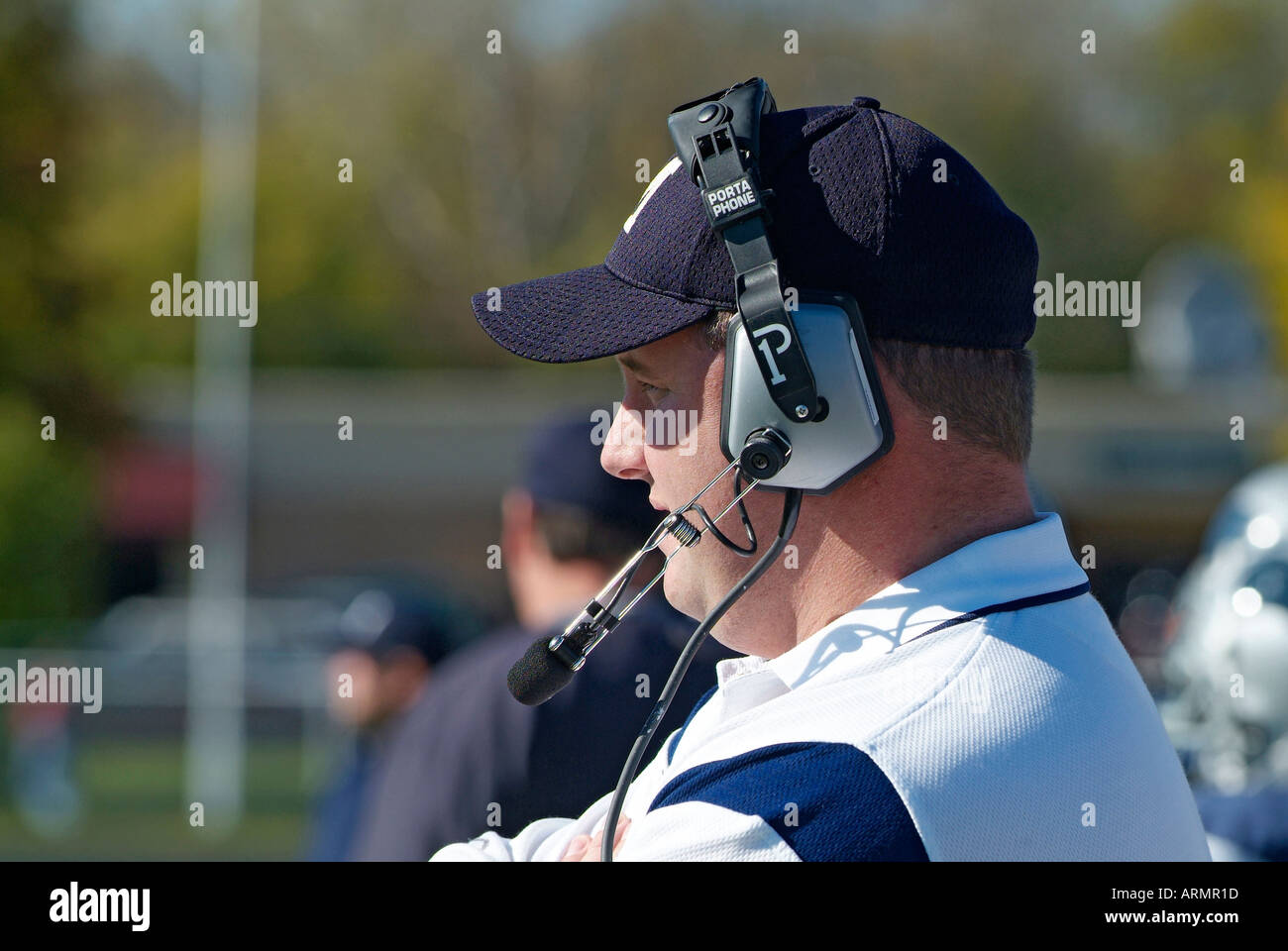 Alta scuola allenatore di calcio di comunicare con altri allenatori per mezzo di cuffie wireless utilizzare Foto Stock