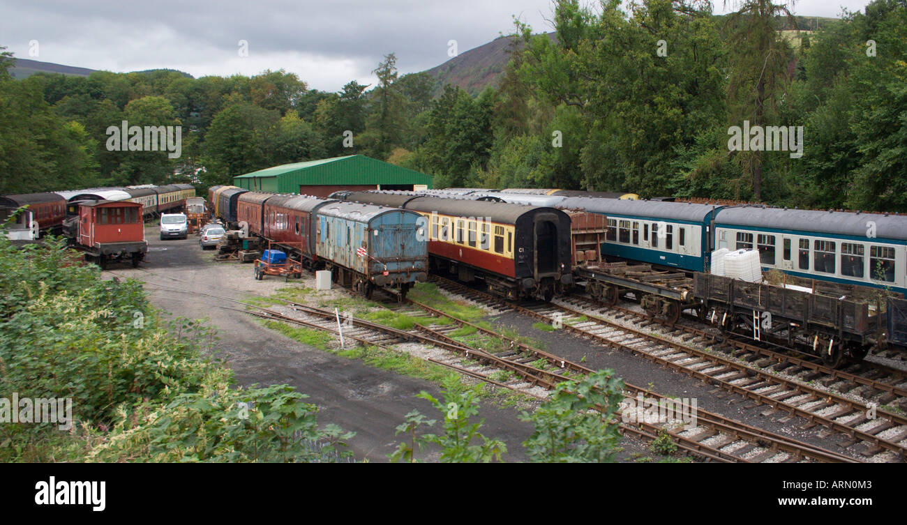 Una raccolta di vecchie vintage vetture e carri ferroviari in schierata in attesa di essere ripristinata. Il Galles. Regno Unito. Foto Stock