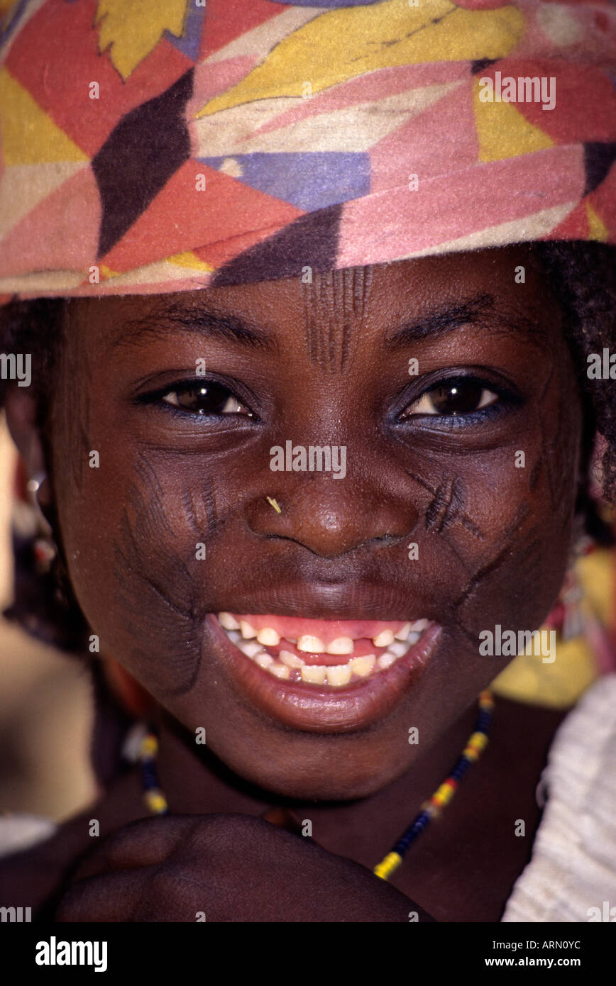 Maraka, Niger, Africa occidentale. Hausa Ragazza con scarificazione del viso per indicare appartenenza tribale. Un pezzo di paglia detiene il posto per un naso pin. Foto Stock