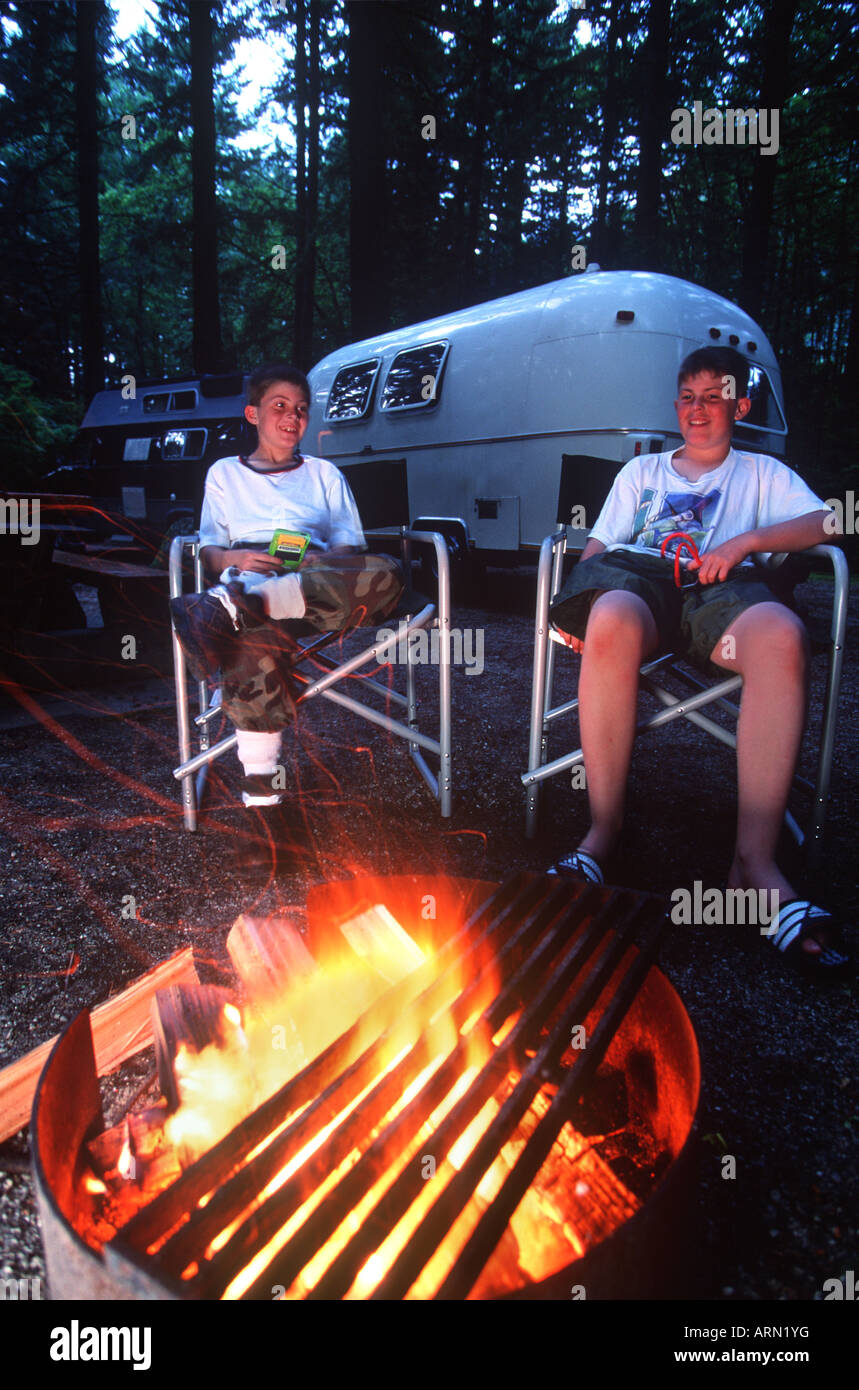 Due ragazzi al campeggio, con contenuti fire, British Columbia, Canada. Foto Stock