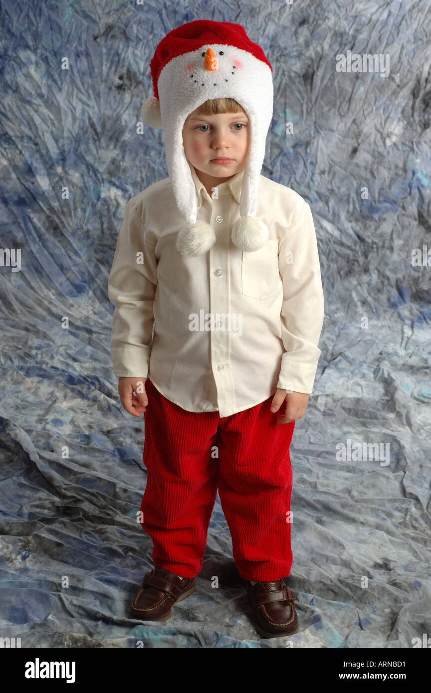 Piccolo Ragazzo infelice circa indossando sciocco cappello di Natale Foto Stock