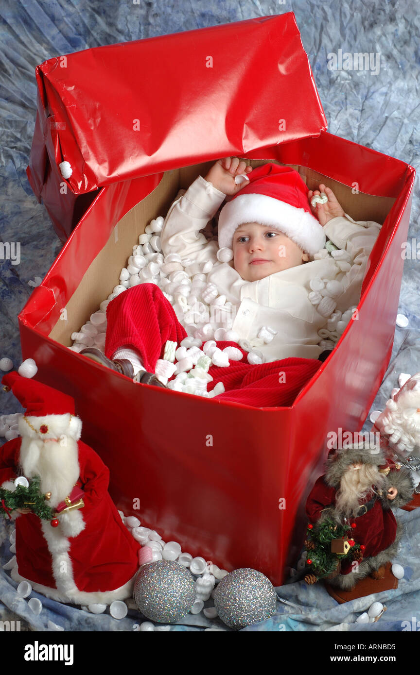 Piccolo Ragazzo nella casella avvolto come vacanze di Natale presente Foto Stock