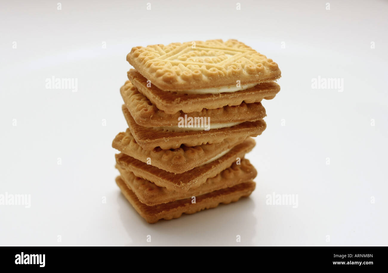 Quattro Crema pasticcera biscotti impilati su una piastra bianca Foto Stock