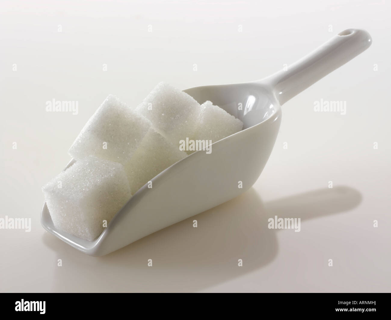 Cubetti di zucchero bianco ancora vita su uno sfondo bianco Foto Stock