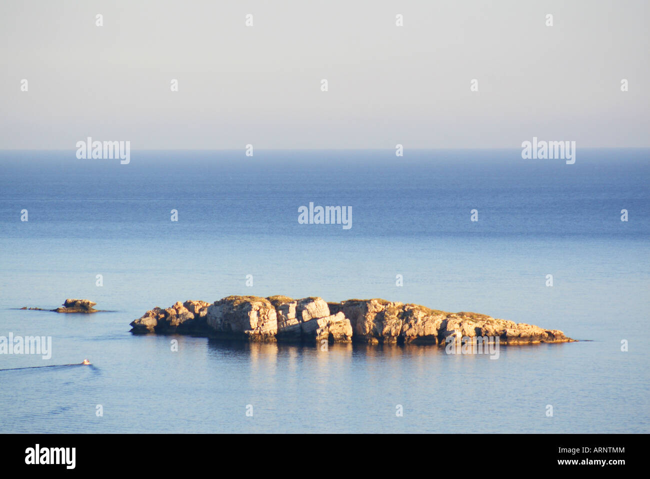Barca motori attraverso il blu mare Mediterraneo con il rocky greco isole costiere Rodi Grecia Foto Stock