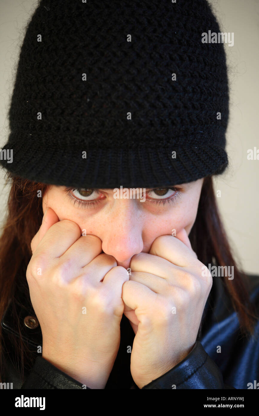 Ritratto di una ragazza, sensibili al freddo, nel cappuccio nero Foto Stock