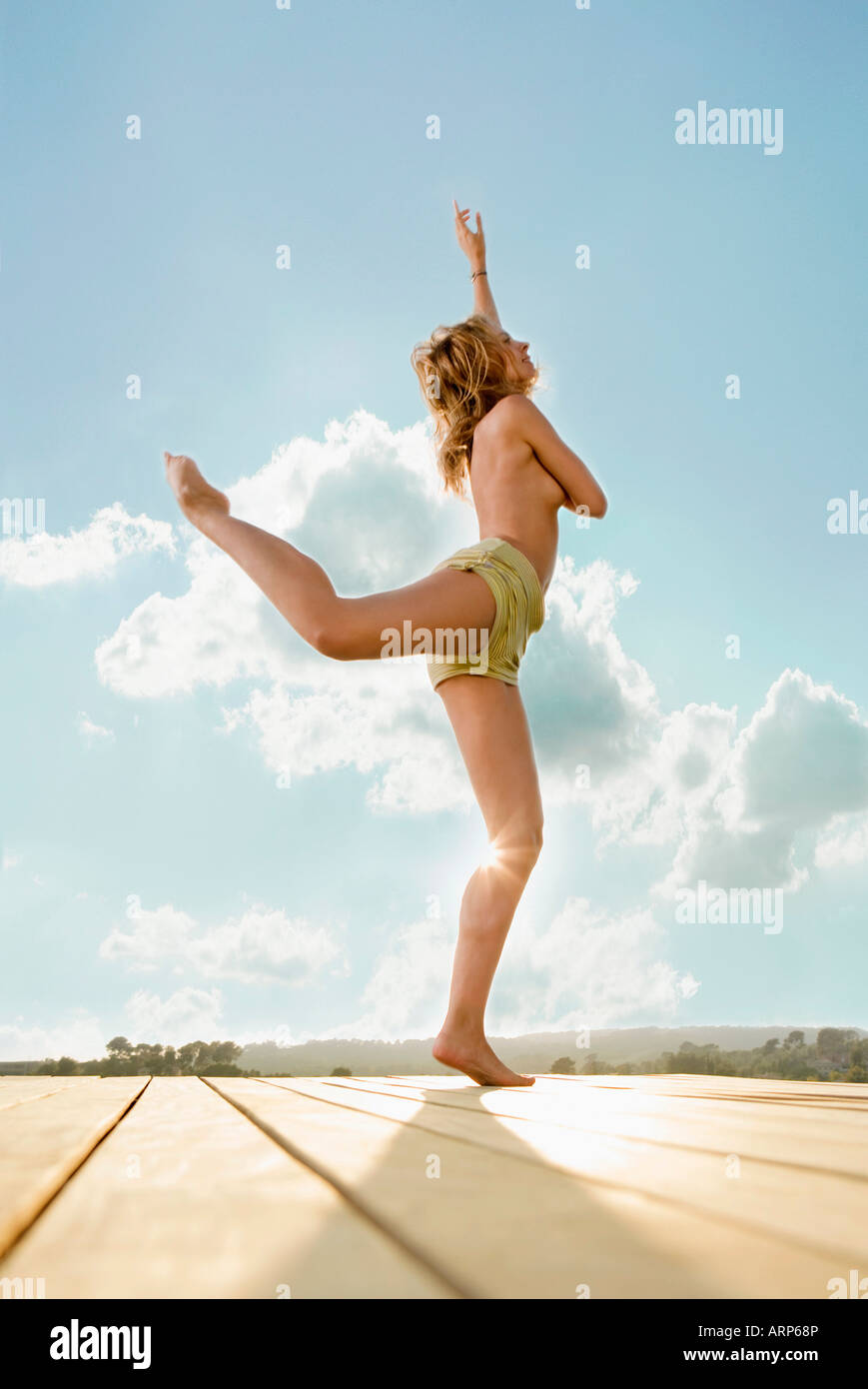 Giovane donna stretching su una terrazza Foto Stock