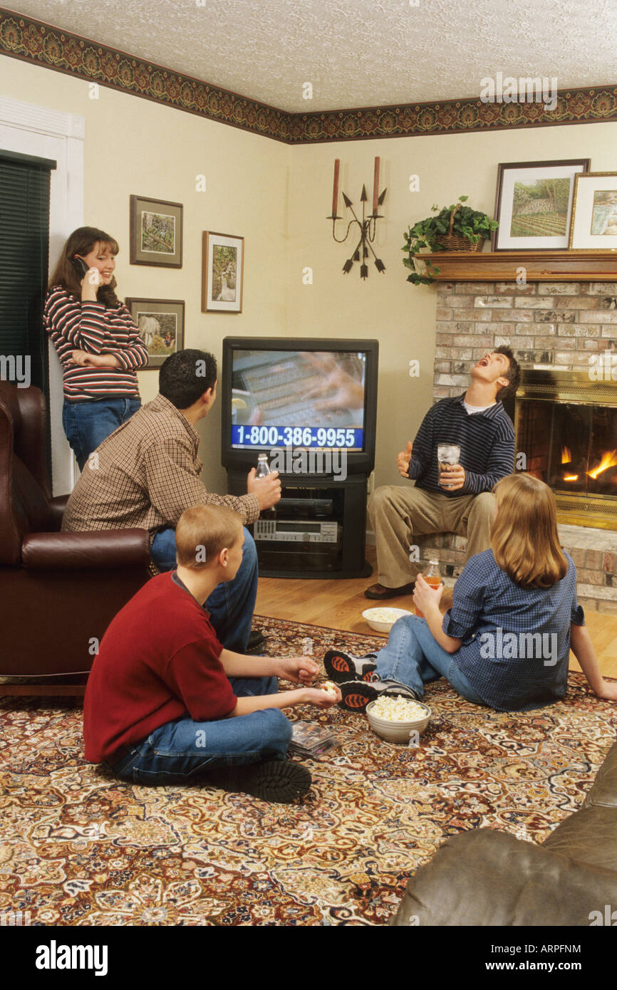 Teens appendere fuori a guardare la televisione, tramite telefono cellulare, mangiando snack, OHIO USA Foto Stock