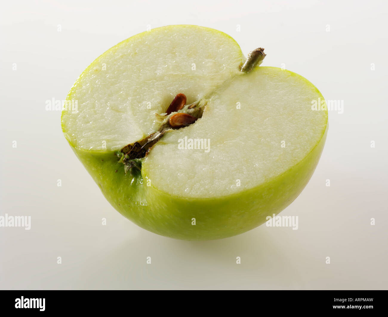 Close up di tagliare la metà Bramley apple isolata contro uno sfondo bianco Foto Stock