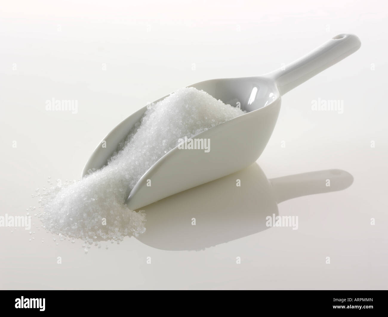 Lo zucchero semolato bianco su sfondo bianco Foto Stock