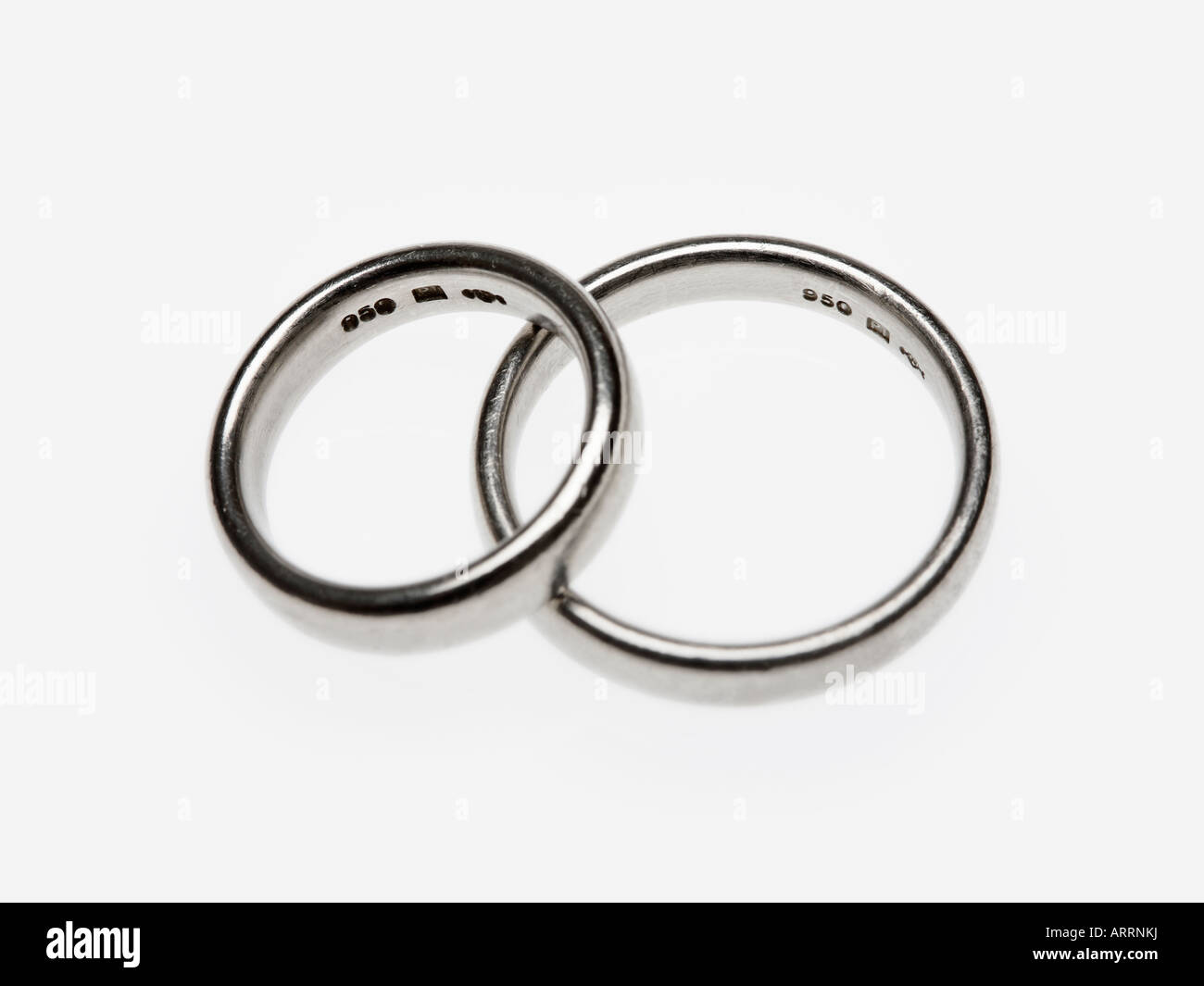 Due anelli di platino con visibili segni distintivi su sfondo bianco - piccolo anello appoggiata contro l'anello di grandi dimensioni Foto Stock