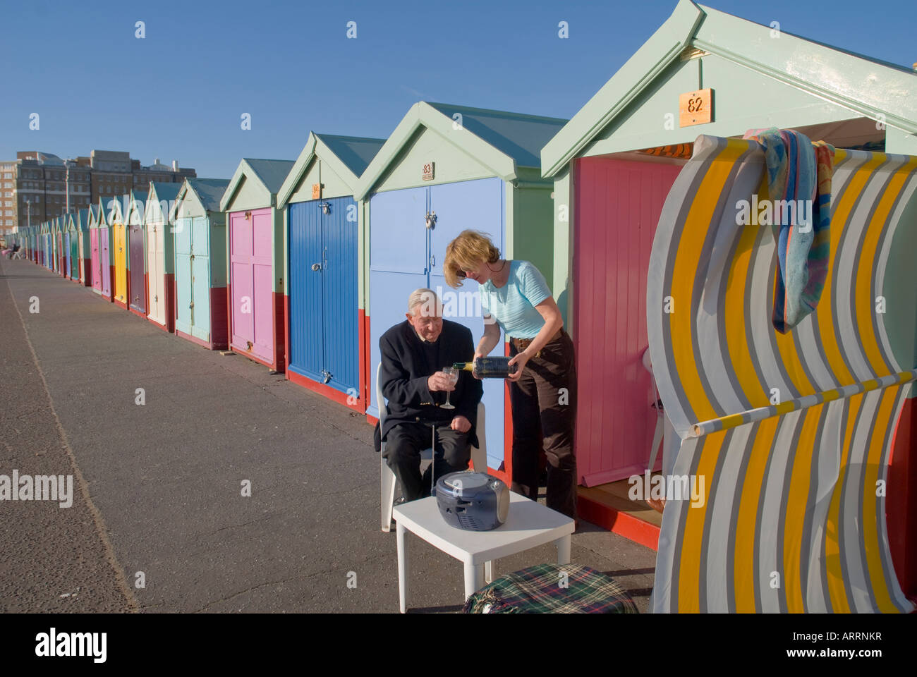 Senior uomo venga versato un drink al Beach Hut. Hove vicino a Brighton Inghilterra Regno Unito Foto Stock