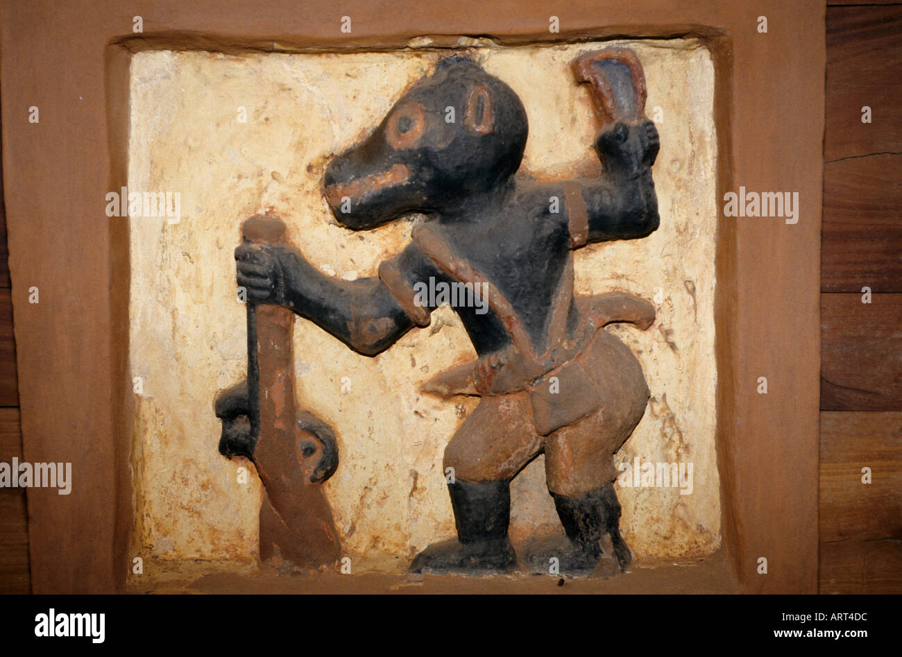 Abomey Benin Palastskulpturen von Abomey restauriert vom Getty Conservation Institute Vom Palast von Glele die Basreliefs zeigten sowohl mythologische Skulpturen wie auch historische Begebenheiten Dieses Bild zeigt einen grimmigen mythischen Krieger namens Daghesson eine menschliche Gestalt mit einem Tierkopf der Feuer spuckt Der Sage nach besass Daghesson eine magische Kraft die Furcht in den Herzen der Feinde erzeugen konnte das Feuer aehnelt dem Blitz des Gottes Fon die gehoernte Figur erinnert an die Bildung des Amazonenbataillons das unter dem Namen Die wuetenden Antilopen bekannt ist Foto Stock