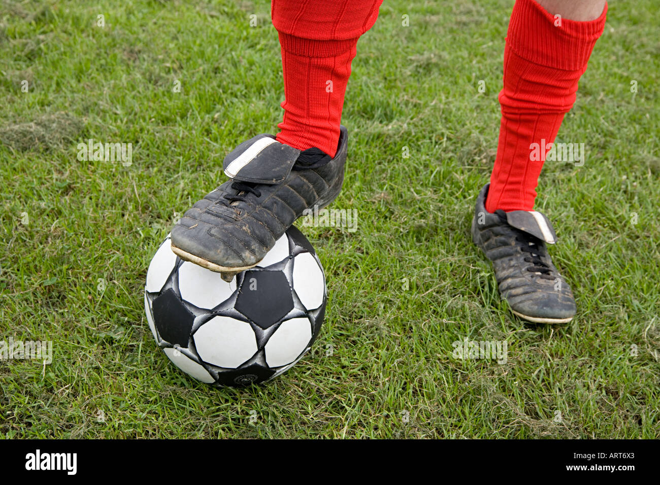 Il calciatore in piedi sul calcio Foto Stock