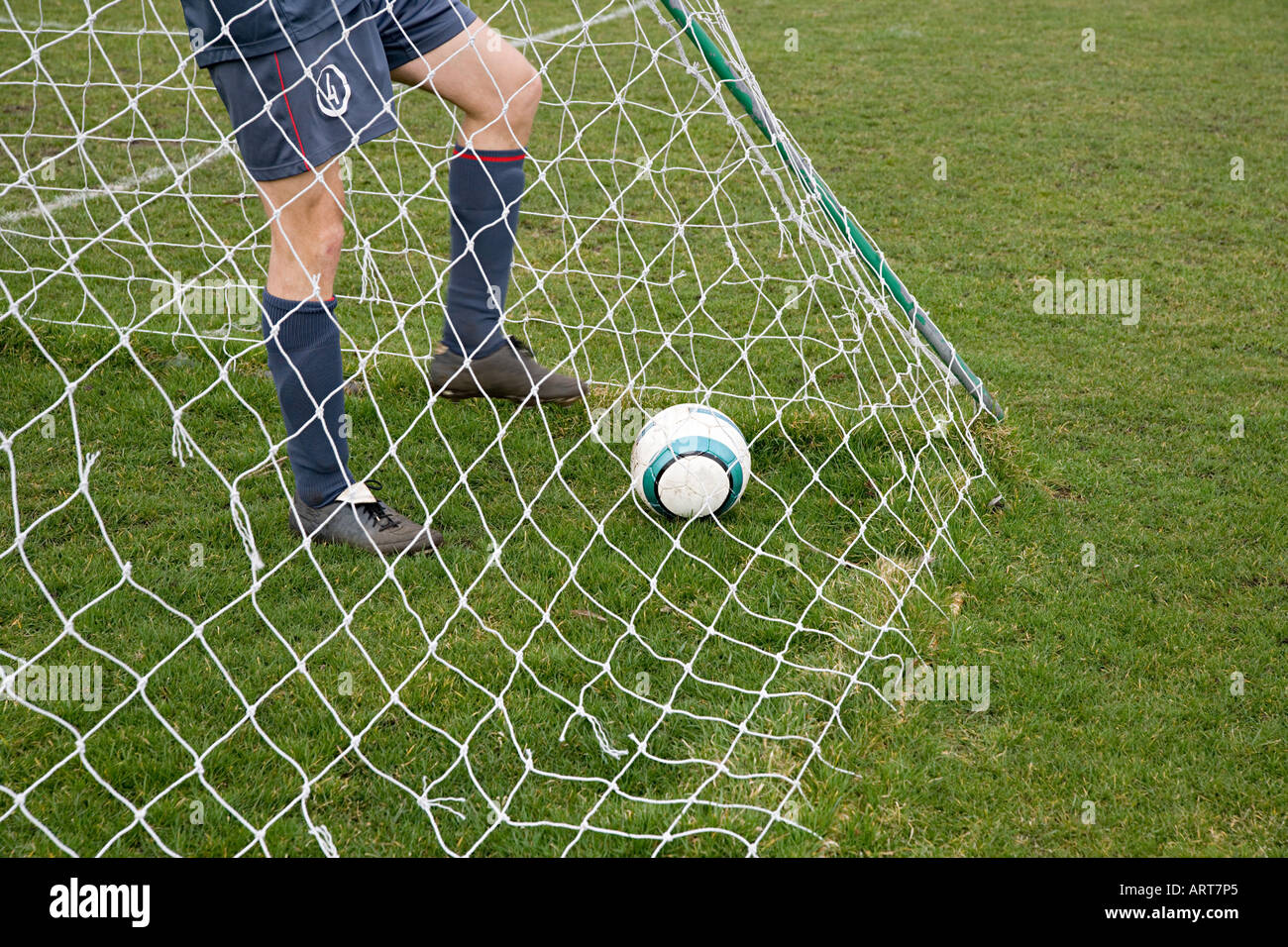 Il calciatore in goal con il calcio Foto Stock