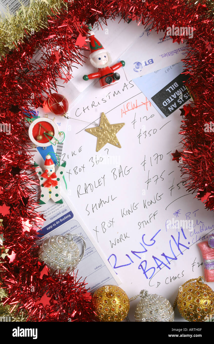 Fatture, estratto conto bancario, tinsel, albero decorazioni e quali estratti conto della carta di credito a circondare una lista dei regali di Natale. Foto Stock