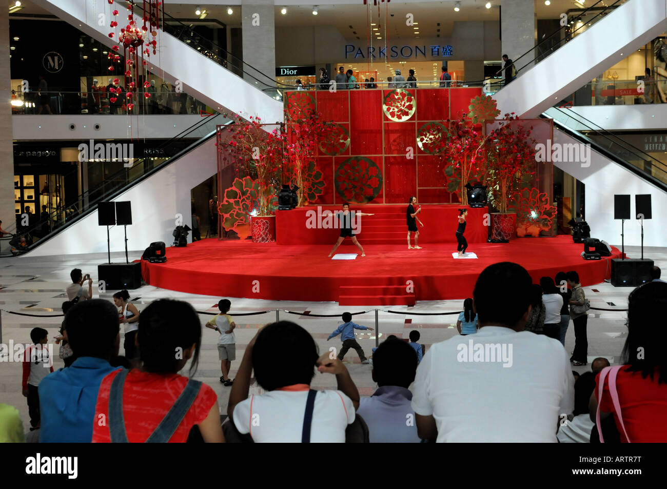 Due esperti di yoga a dare una dimostrazione delle pose diverse in corrispondenza di un complesso di negozi, Pavilion a Kuala Lumpur Foto Stock