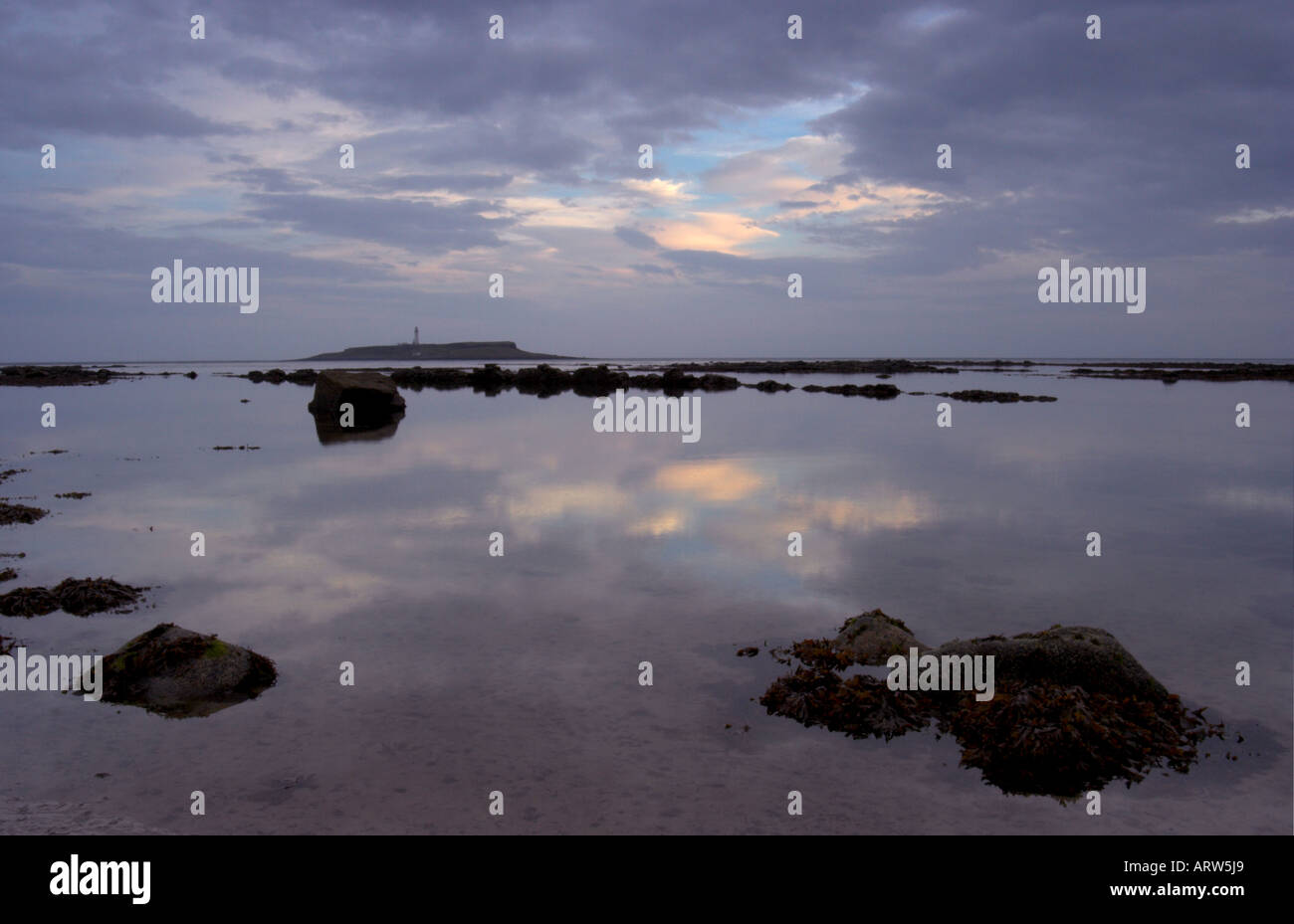 Foto paesaggio del litorale di Kildonan sull'isola di Arran al tramonto con Pladda island e il faro in background Foto Stock