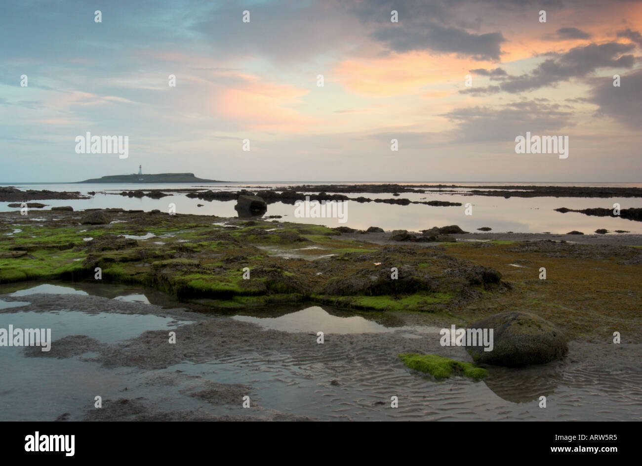 Foto paesaggio del litorale di Kildonan sull'isola di Arran al tramonto con Pladda island e il faro in background Foto Stock