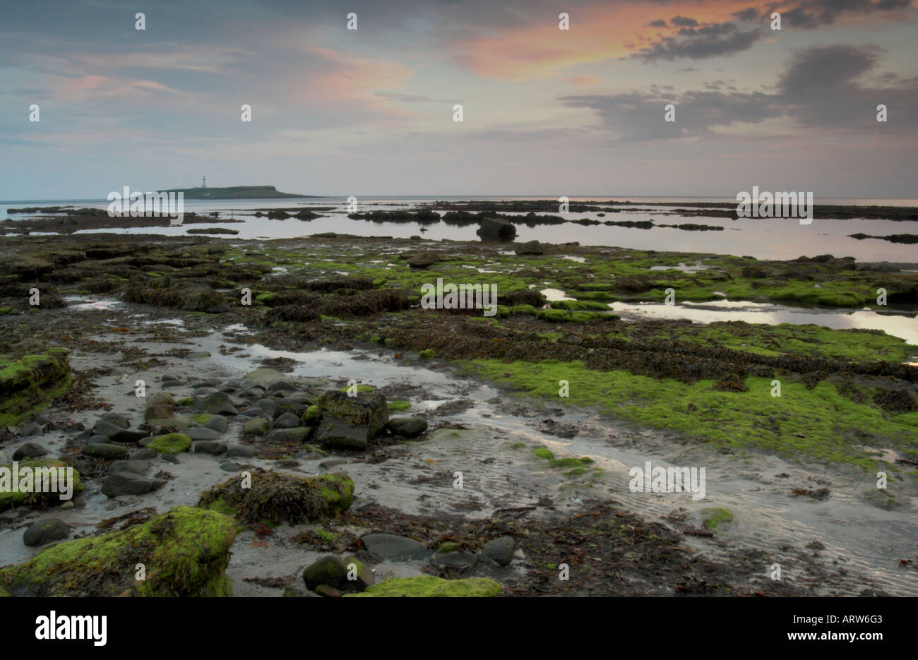 Foto paesaggio del litorale di Kildonan sull'isola di Arran al tramonto con Pladda island e il faro in background Foto Stock