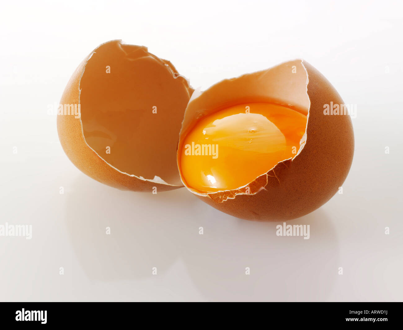 Organico marrone a Burford uovo incrinato nella metà mostra tuorlo Foto Stock