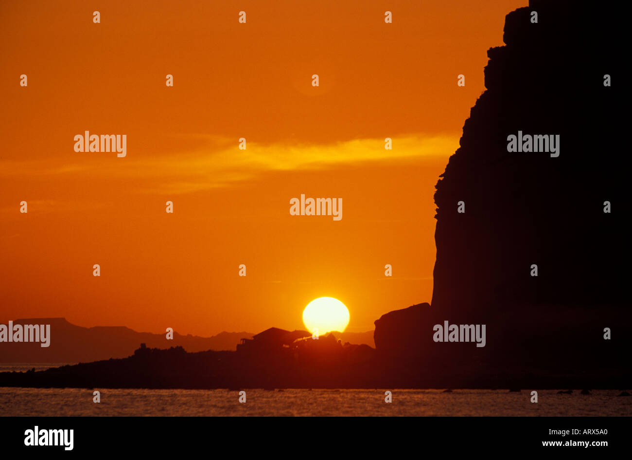 Messico Baja Mar di Cortes arancione e rosso tramonto contro scogliere rocciose isola Espiritu Santos Foto Stock