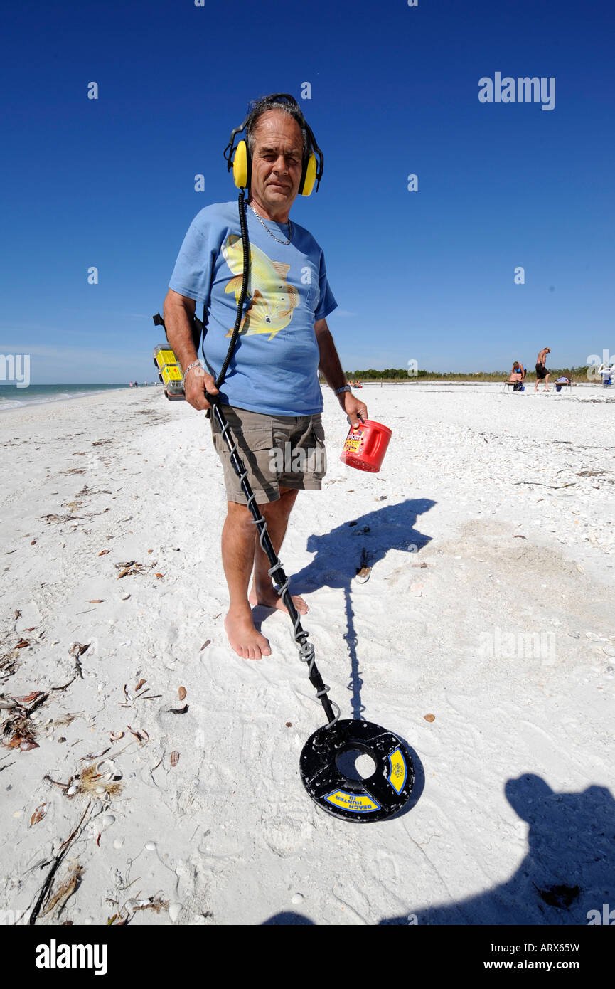 Senior maschio utilizza metal detector per trovare gli oggetti su una  spiaggia a Napoli Florida Foto stock - Alamy