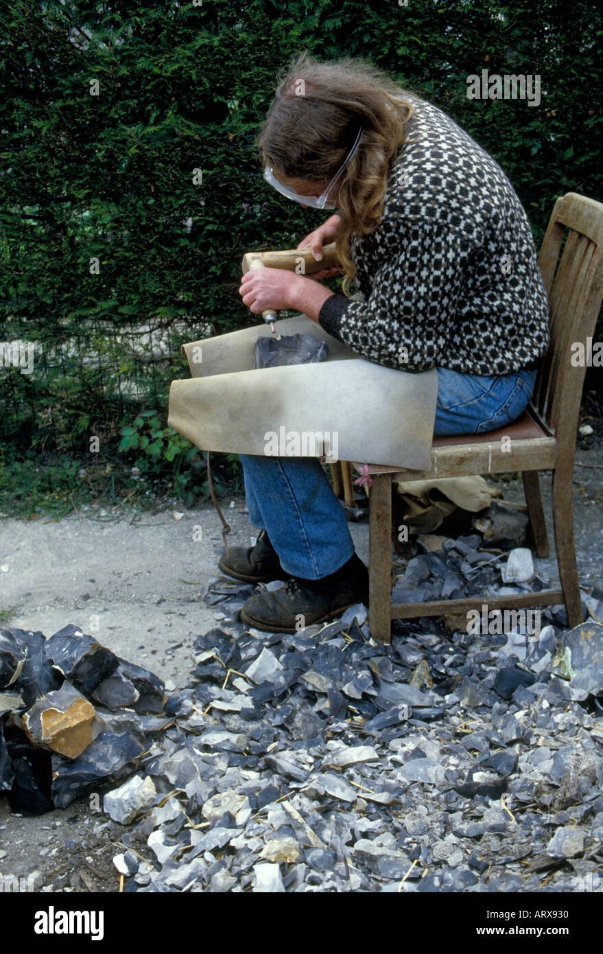 TV archeologo Phil Harding è una pietra focaia tight suo uno dei mondi più antica abilità di indossare gli occhiali di protezione per proteggere gli occhi. Foto Stock