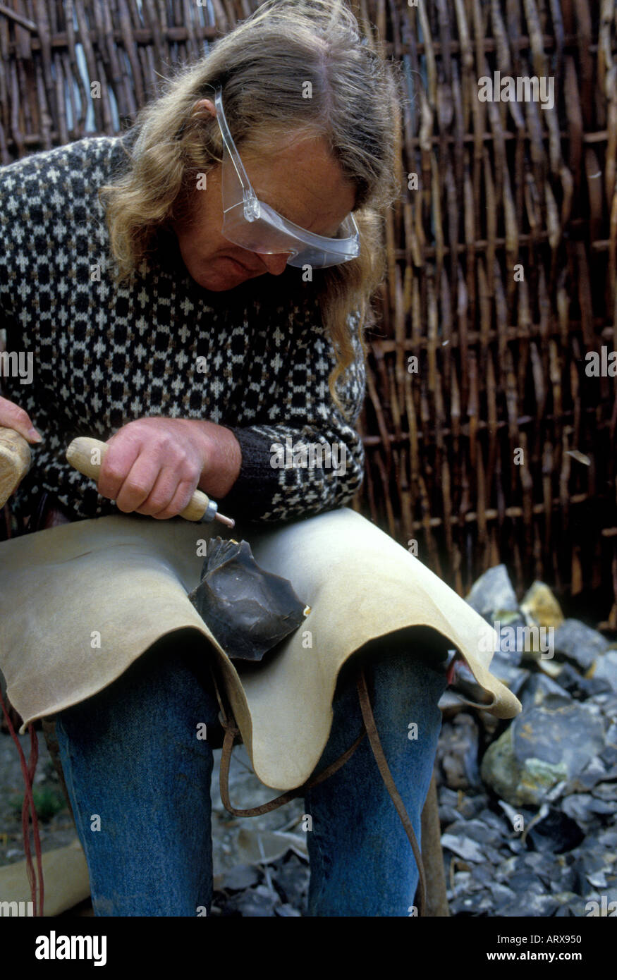 TV archeologo Phil Harding è una pietra focaia tight suo uno dei mondi più antica abilità di indossare gli occhiali di protezione per proteggere gli occhi. Foto Stock
