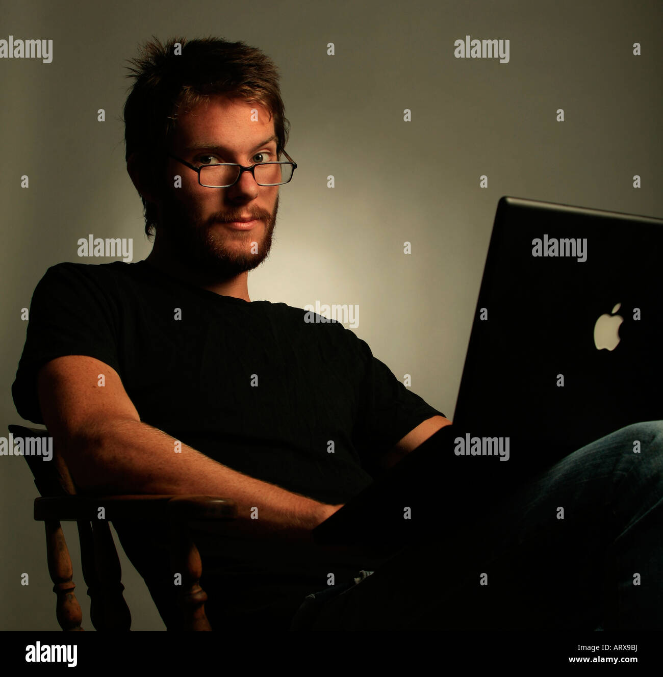 Giovane uomo con gli occhiali e il computer Foto Stock