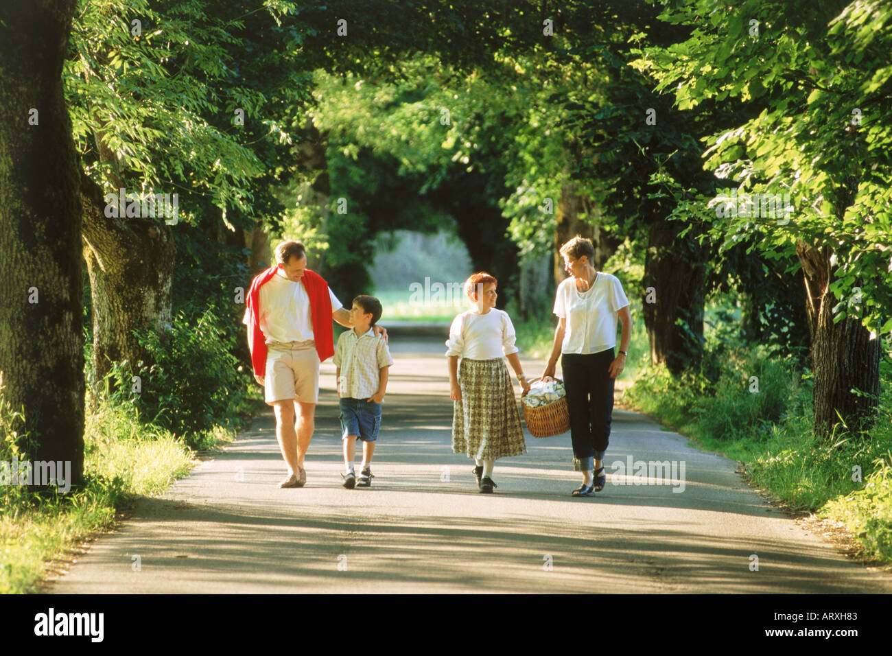 Famiglia di quattro sulla strada di campagna godendo picnic estivo in Baviera Germania Foto Stock