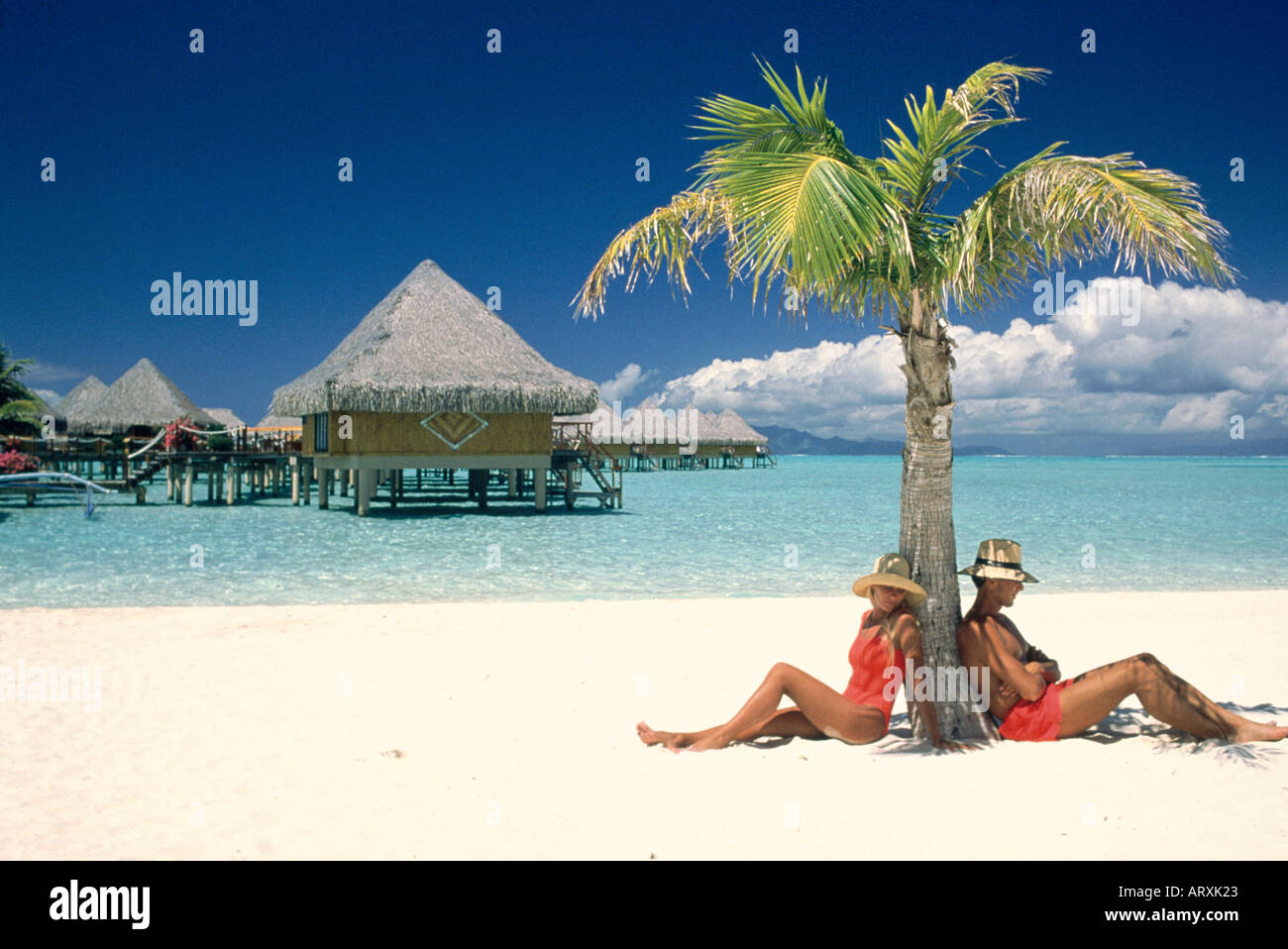 Matura in appoggio sotto il palm Tree sulla spiaggia di sabbia bianca Foto Stock