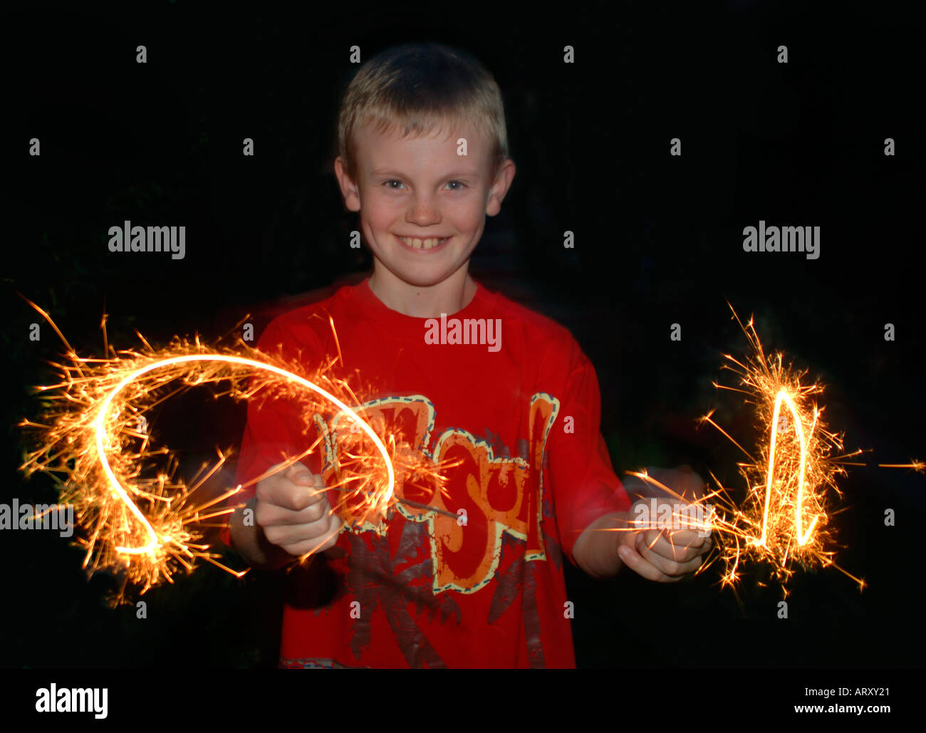 Boy utilizzando un fuoco d'artificio botti di dipingere con la luce. Foto Stock