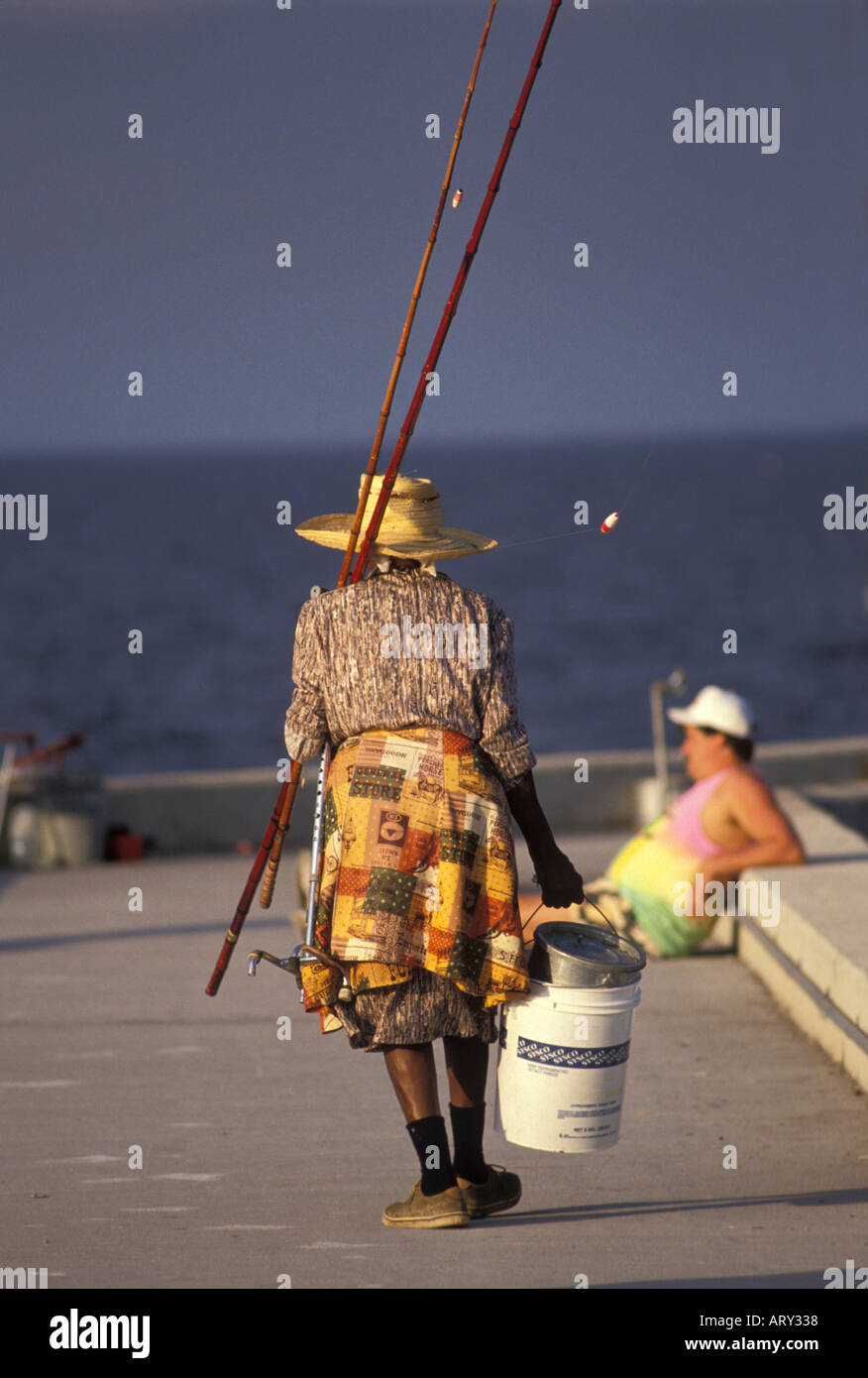 I residenti locali di pesca al largo di un molo a Pahokee Florida sul lago Okeechobee con canna poli di pesca Foto Stock